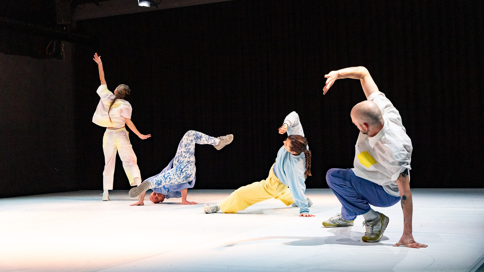 Vier Tänzer:innen von deciphered in Bewegung auf der Bühne beim TanzTausch Festival